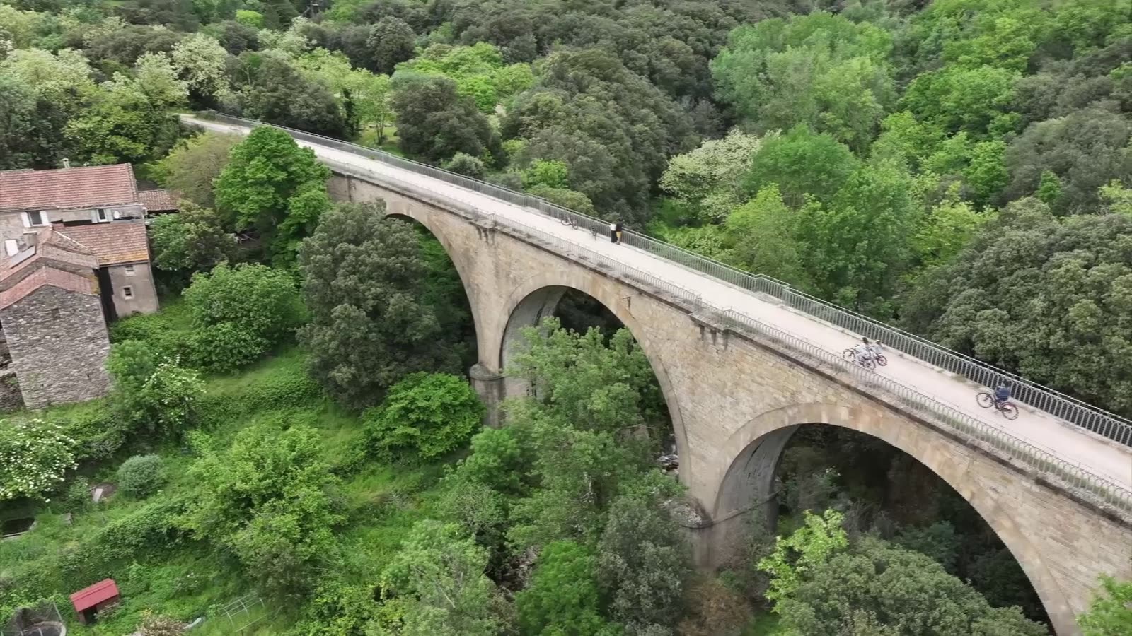 Groupe de cyclistes traversant le viaduc du Caroux